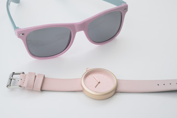 close up of wristwatches with sunglasses for background