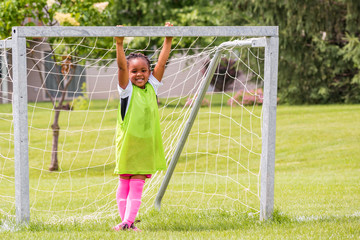 A young girl is learning how to play soccer
