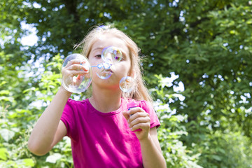 girl blows soap bubbles