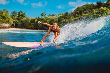 Fototapeten Beautiful surfer girl on surfboard. Woman in ocean during surfing in Bali © artifirsov