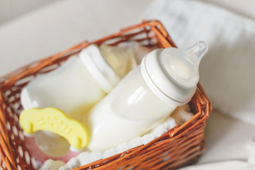Two bottles with breast milk for baby in a straw basket. Free copy space. - 210778438