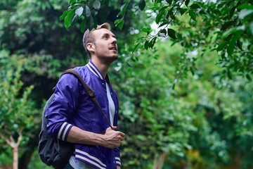 Man traveling in the forest with backpack