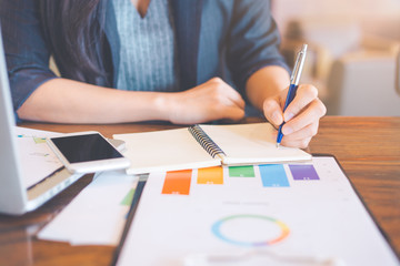 Business woman are writing analysis logs about charts and graphs that show results in the office.