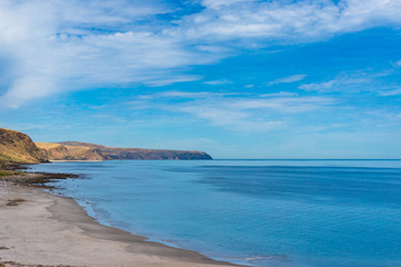 Ocean coastline with sandy beach and picturesque hills