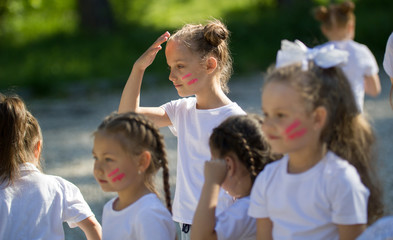 Caucasian little girls team with painted faces playing in summer park