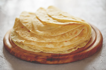 Homemade tortillas on the wooden cutting board.