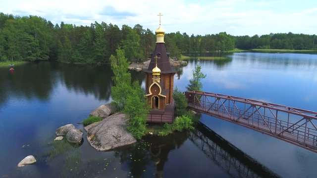 Summer landscape of the Vuoksa river with a wooden Church of St. Andrew. Russia