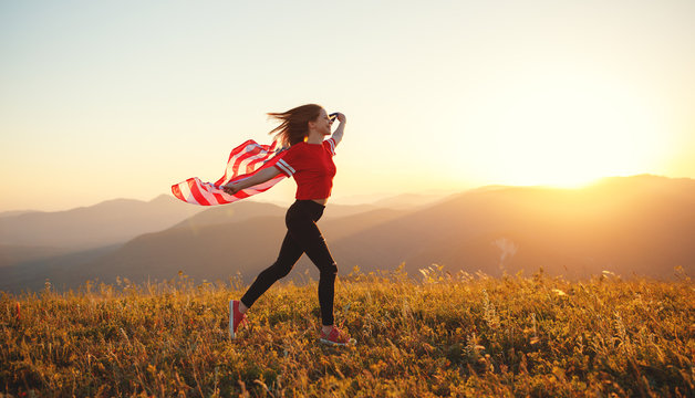 happy woman with flag of united states enjoying the sunset on nature.