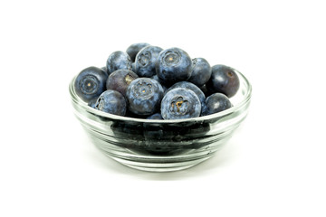 Blueberries in the transparent glass bowl on the white background