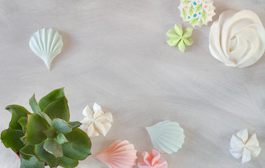 Flat lay simple organic candy meringue pastel dessert and succulents on white texture background with copy space