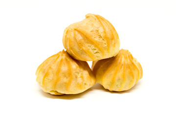 Heap of three profiteroles isolated on white