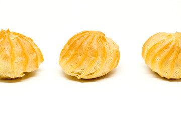 Row of three profiteroles isolated on the white background