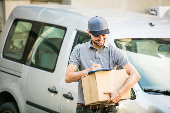  Delivery Man With Cardbox In Hands On The Streets