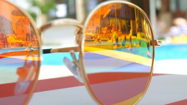 Sunglasses. Pool reflection. Concept of holiday at sea. Observations children, play.