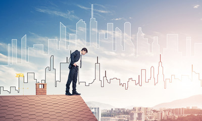 Businessman looking down from roof and modern cityscape at backg