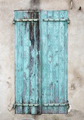 old wooden blue green peeling shutters in french provence house