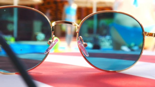 Sunglasses. Pool reflection. Concept of holiday at sea. Observations children, play. TimeLapse.