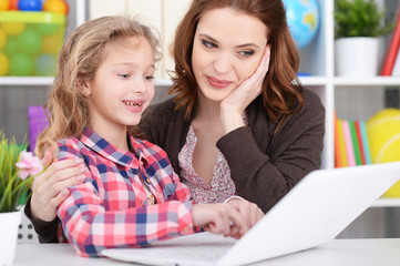 mother and daughter using laptop