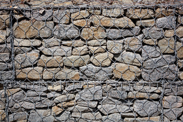 Stone wall in a metal grid as a background