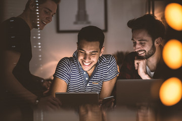 Happy friends watching funny movie on Saturday evening at home