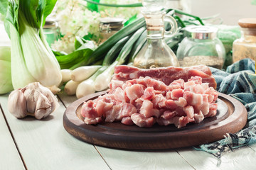 Raw pork belly pieces on a cutting board