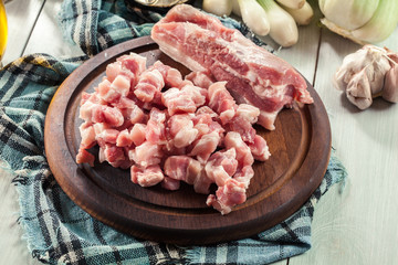 Raw pork belly pieces on a cutting board