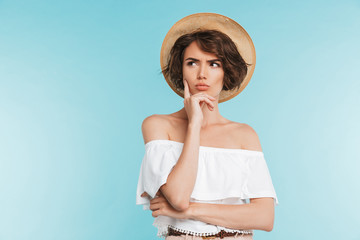 Portrait of a pensive young woman in summer hat
