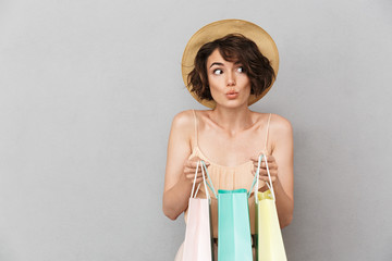 Portrait of a curious young woman in summer hat