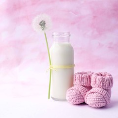 Its a girl pink theme baby shower or sip and see party background with decorative elements - booties and milk bottle. Minimal, copy space.