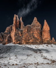 Tre Cime di Lavaredo, beautiful mountain landscape. Small figures of people at the foot of a peak.