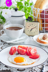 Breakfast of scrambled eggs, fresh tomatoes, coffee with milk, bread with honey, selective focus