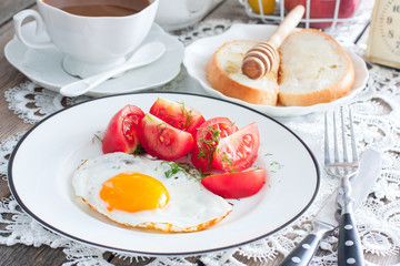 Fried eggs, fresh tomatoes, coffee, bread, horizontal