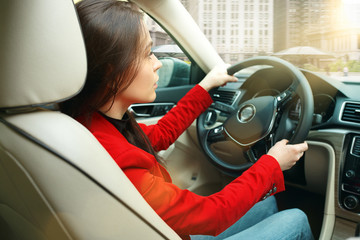 Driving around city. Young attractive woman driving a car