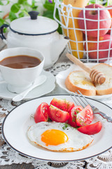 Breakfast of scrambled eggs, fresh tomatoes, coffee with milk, bread with honey, selective focus