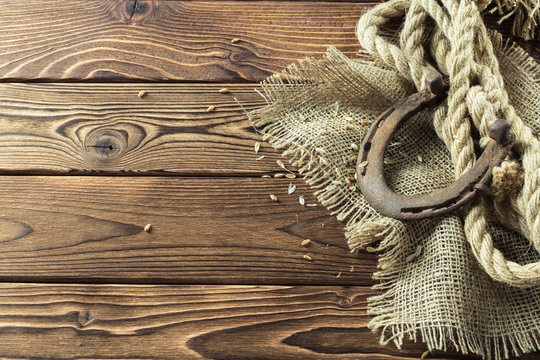 Old horseshoe and rope on wooden boards