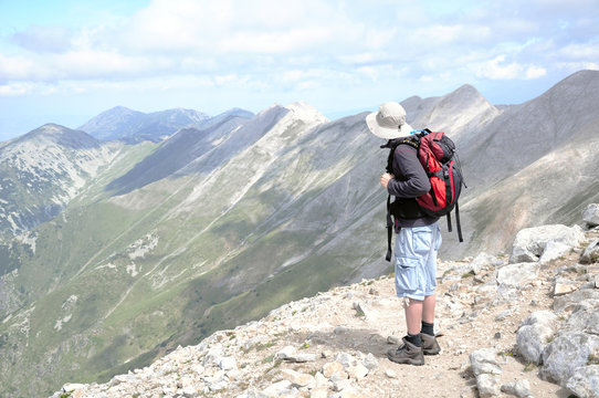 Man shoot from the back standing looking at mountain view at Vihren summit, Pirin, Bansko, Bulgaria