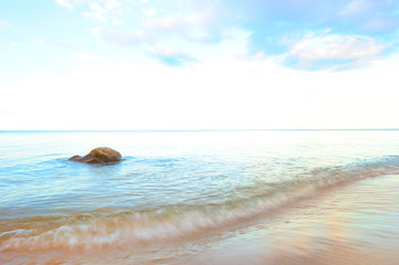 Stein im Meer mit Strand