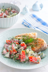Fried fish with fresh tomato and cucumber salad, selective focus