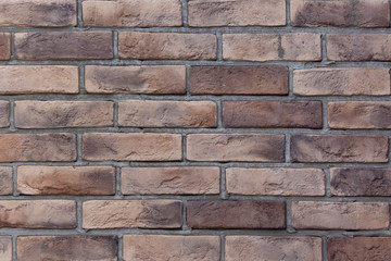 Brick wall with variegated brown bricks. Used as a background.