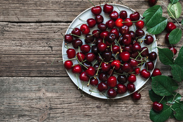 Fresh cherry on plate on rustic wooden background. fresh ripe berries. sweet cherries