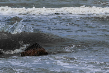 sea wave covers the stone, black sea