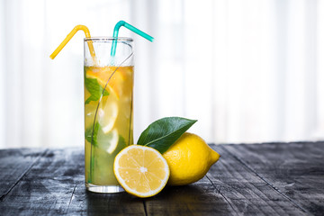 Refreshing lemonade with mint on glass on black background