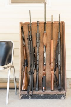 Various guns arranged in wooden rack