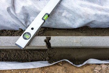 Setting of edge restraints with border stones in concrete with bubble level
