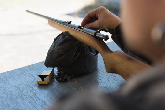 Man Loading Bullet Into Shotgun