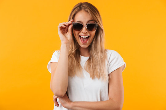Portrait of an excited young blonde girl in sunglasses