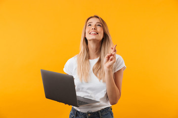 Portrait of a smiling young blonde girl holding laptop