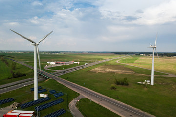 Aerial view of windmills with solar panel on the field on sunny 