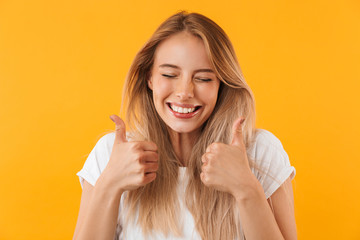 Portrait of a joyful young girl showing two thumbs up
