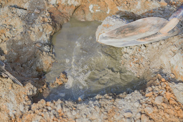  pooring water to the mixture of sand and cement. Making cement at construction cite,